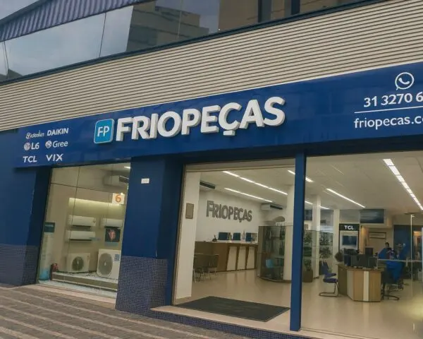Fachada comercial moderna da loja Friopeças, com revestimento em ACM azul, letreiro em alto-relevo e identidade visual corporativa destacando marcas de climatização — exemplo de fachada comercial elegante e funcional.